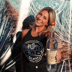 brand ambassador posing with 813 tequila bottle